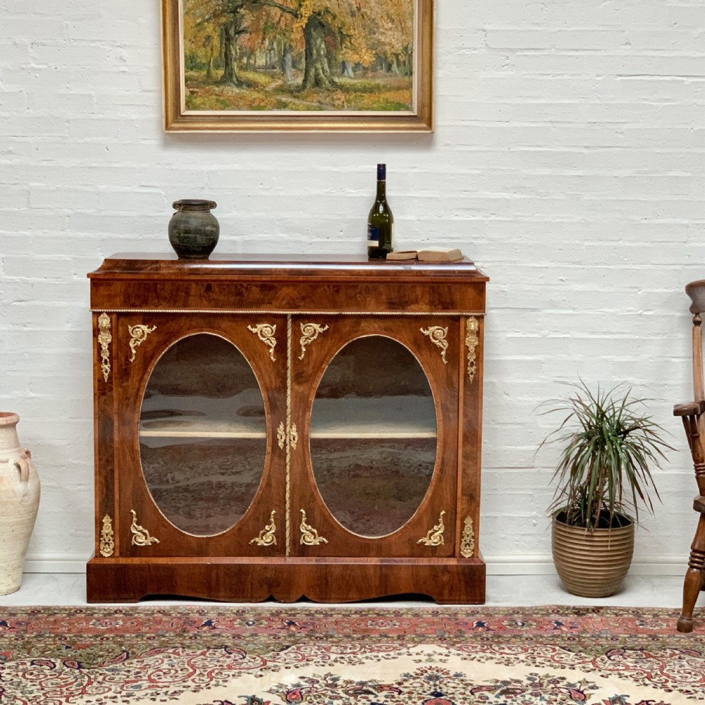 A Victorian double-door pier cabinet featuring figured walnut veneers, oval glass door panels, and decorative brass mounts. View II