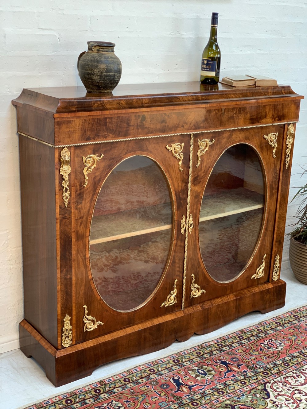 A Victorian double-door pier cabinet featuring figured walnut veneers, oval glass door panels, and decorative brass mounts. View III