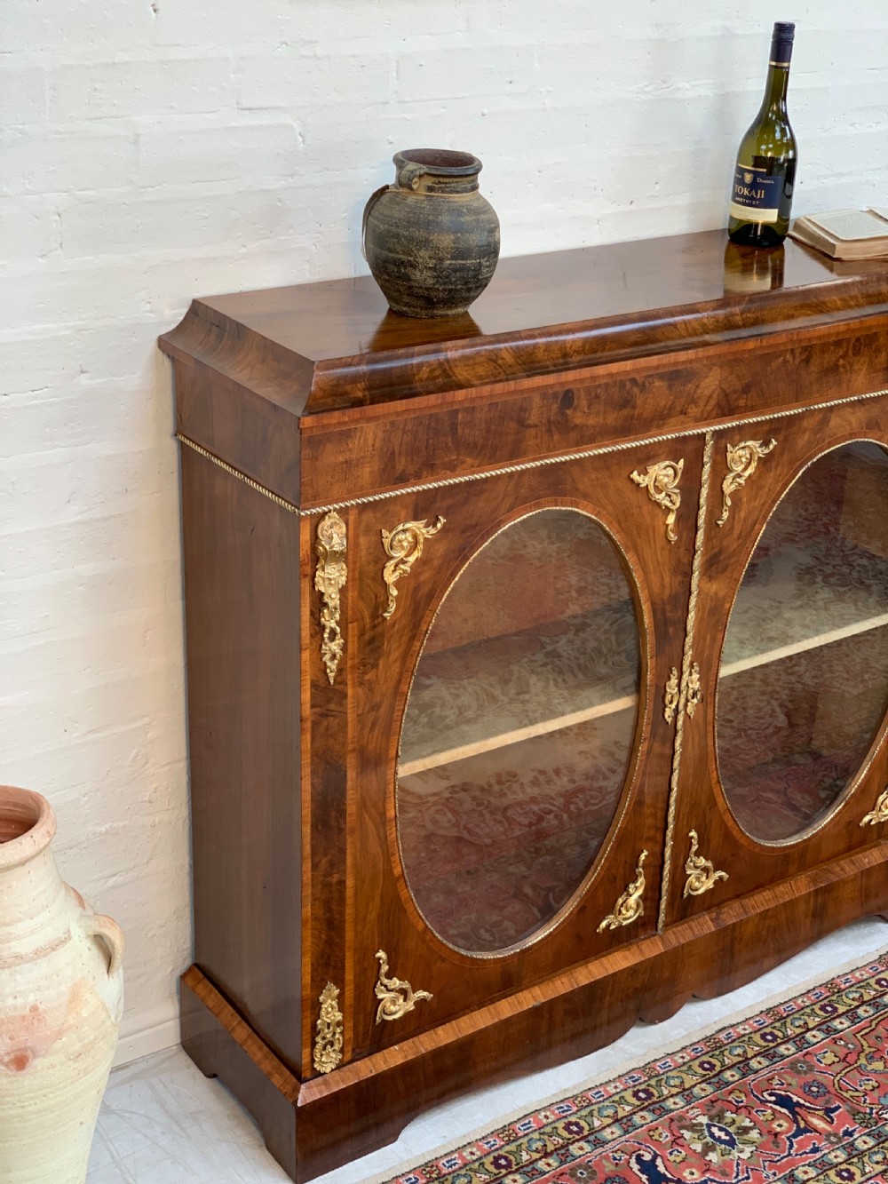 A Victorian double-door pier cabinet featuring figured walnut veneers, oval glass door panels, and decorative brass mounts. View IV