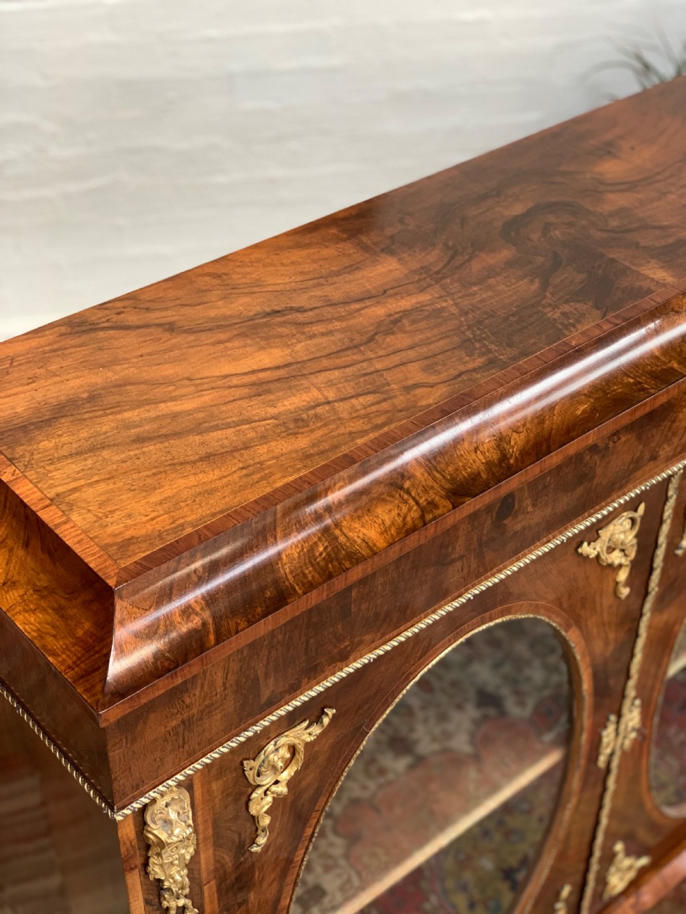 A Victorian double-door pier cabinet featuring figured walnut veneers, oval glass door panels, and decorative brass mounts. View VIII