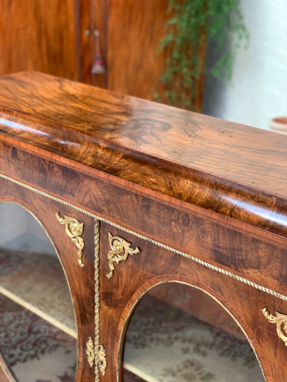 A Victorian double-door pier cabinet featuring figured walnut veneers, oval glass door panels, and decorative brass mounts. View IX