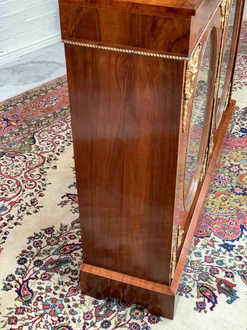 A Victorian double-door pier cabinet featuring figured walnut veneers, oval glass door panels, and decorative brass mounts. View X