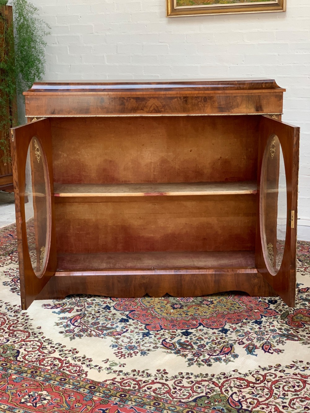 A Victorian double-door pier cabinet featuring figured walnut veneers, oval glass door panels, and decorative brass mounts. View XII