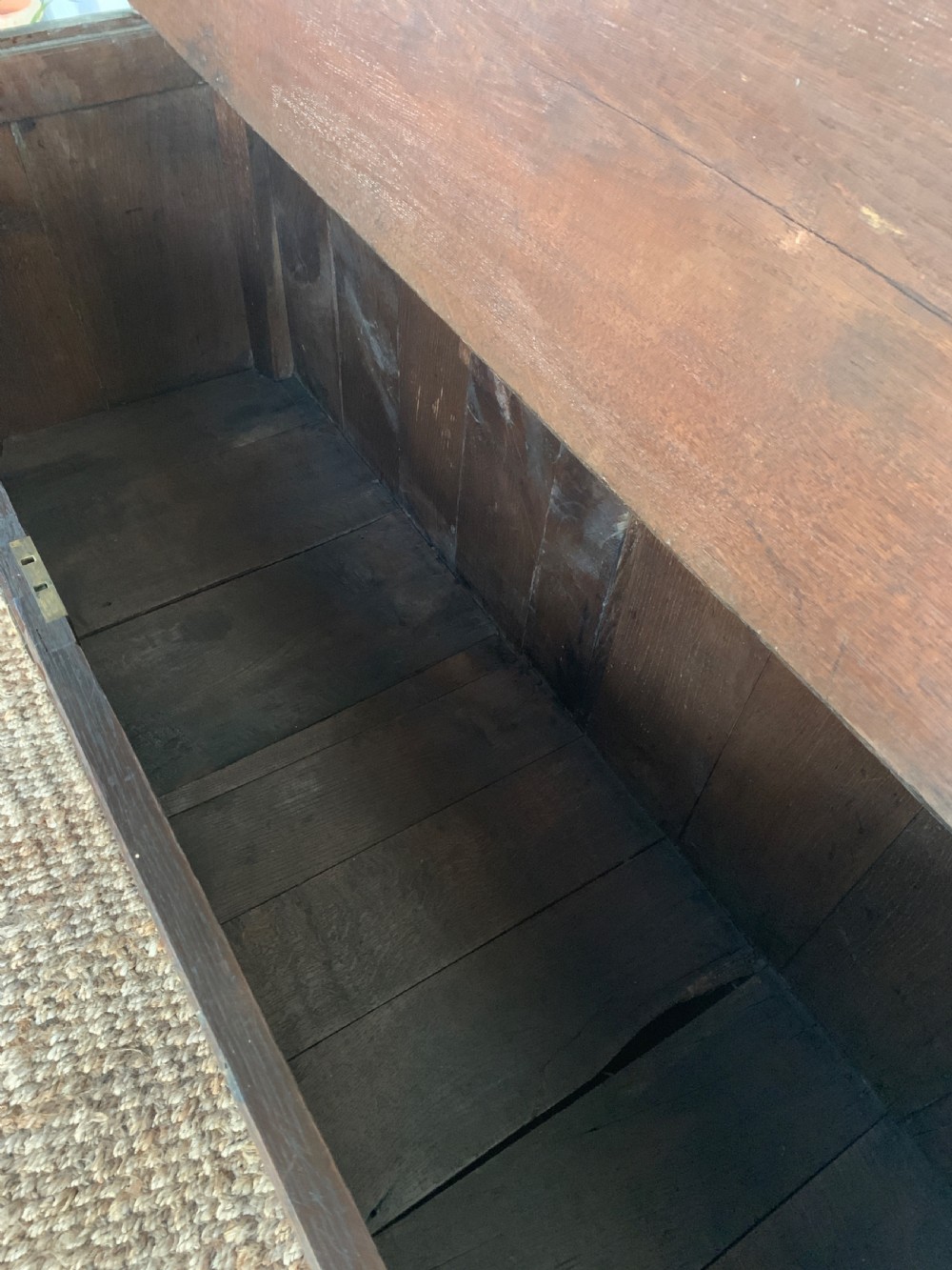 A dark oak mule chest featuring a hinged top, raised arched panels, multiple lower drawers, and brass batwing handles. View VIII