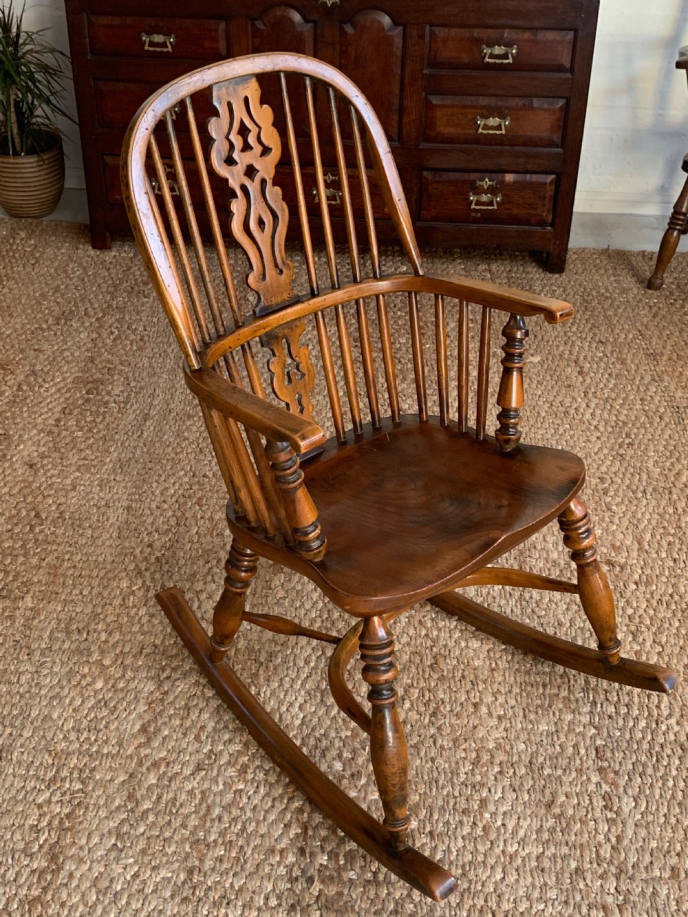A nineteenth-century country-style Windsor rocking chair featuring a hoop back, central pierced splat, turned spindles, and shaped armrests on curved wooden rockers. View VIII