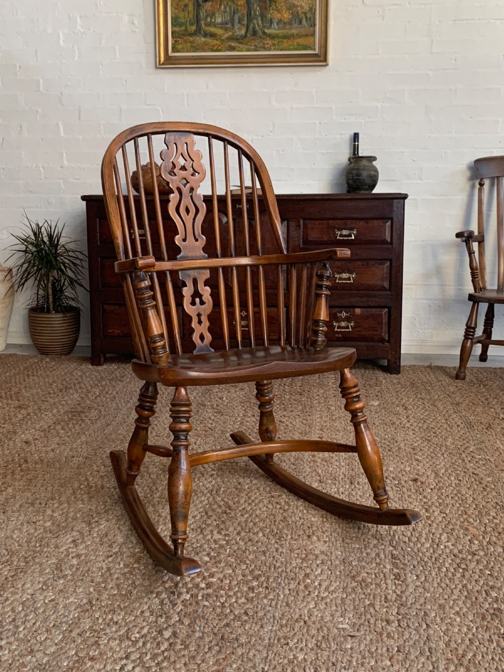A nineteenth-century country-style Windsor rocking chair featuring a hoop back, central pierced splat, turned spindles, and shaped armrests on curved wooden rockers. View IX