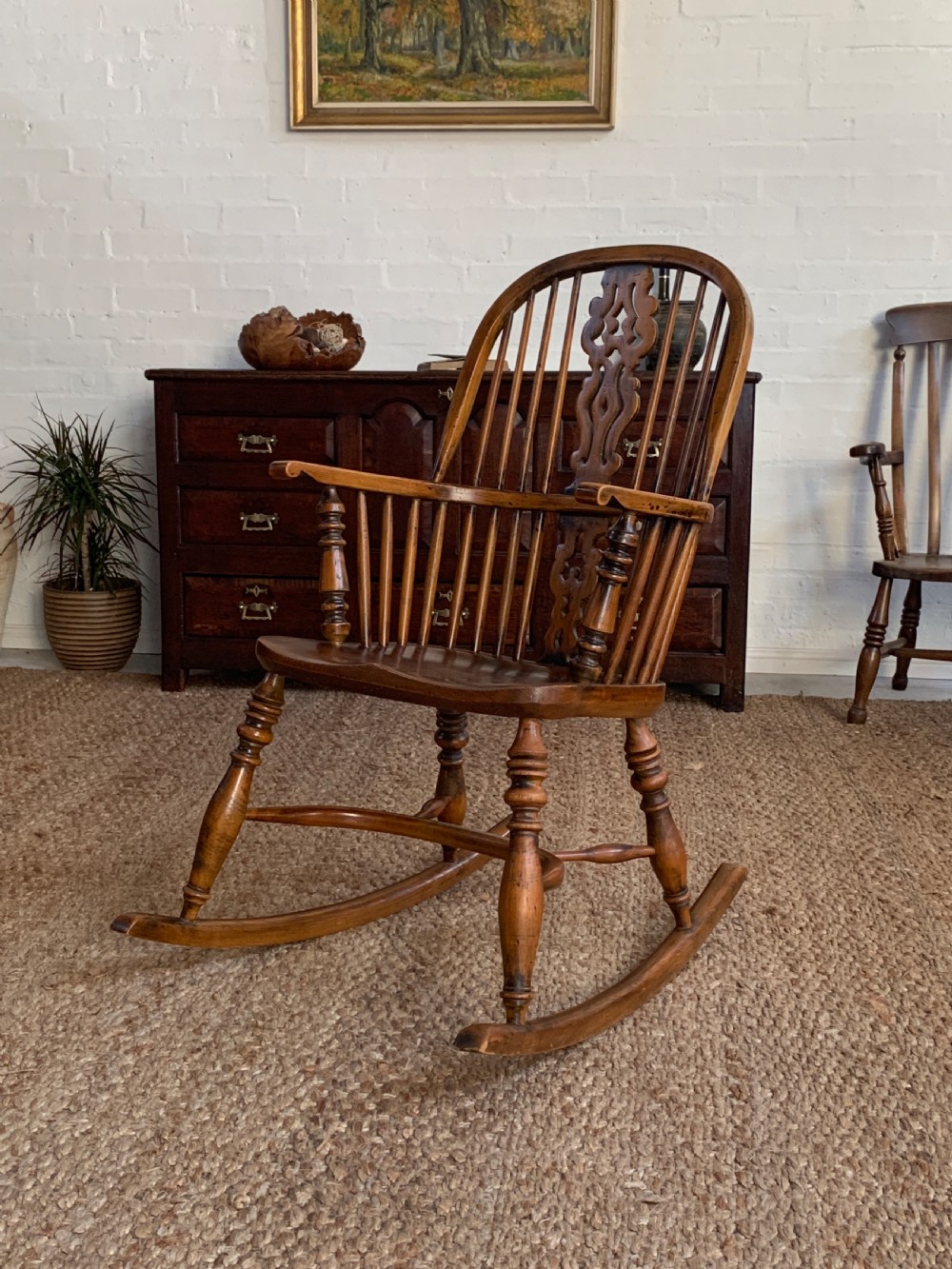 A nineteenth-century country-style Windsor rocking chair featuring a hoop back, central pierced splat, turned spindles, and shaped armrests on curved wooden rockers. View X
