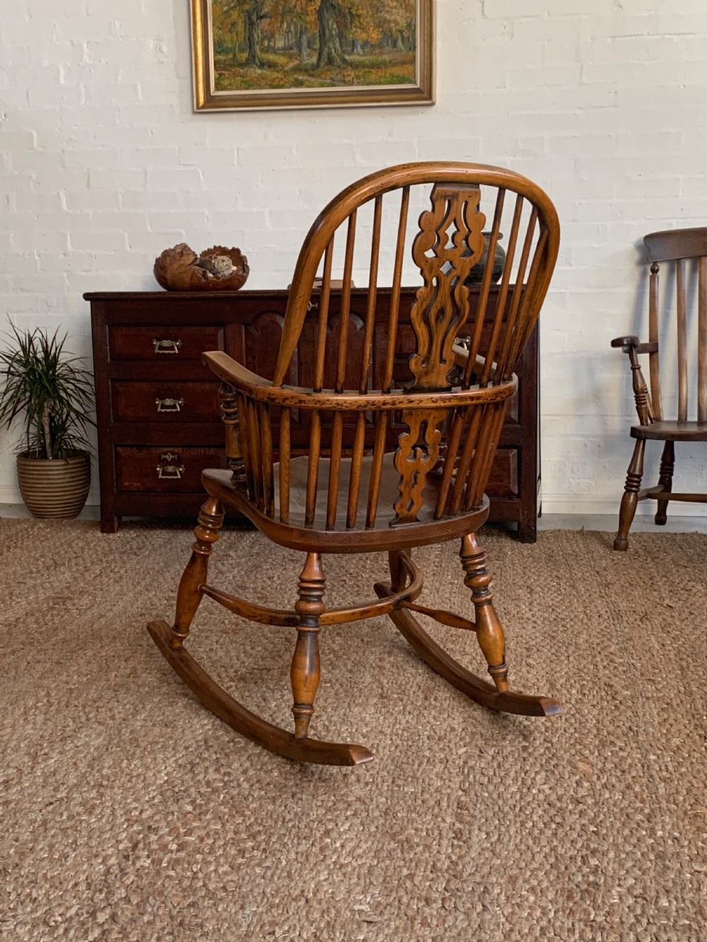 A nineteenth-century country-style Windsor rocking chair featuring a hoop back, central pierced splat, turned spindles, and shaped armrests on curved wooden rockers. View XII