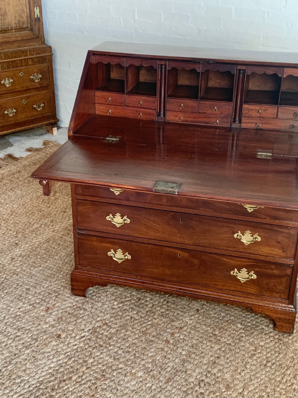 A Georgian mahogany slant-front writing bureau featuring four graduated drawers with brass batwing handles and bracket feet. View III