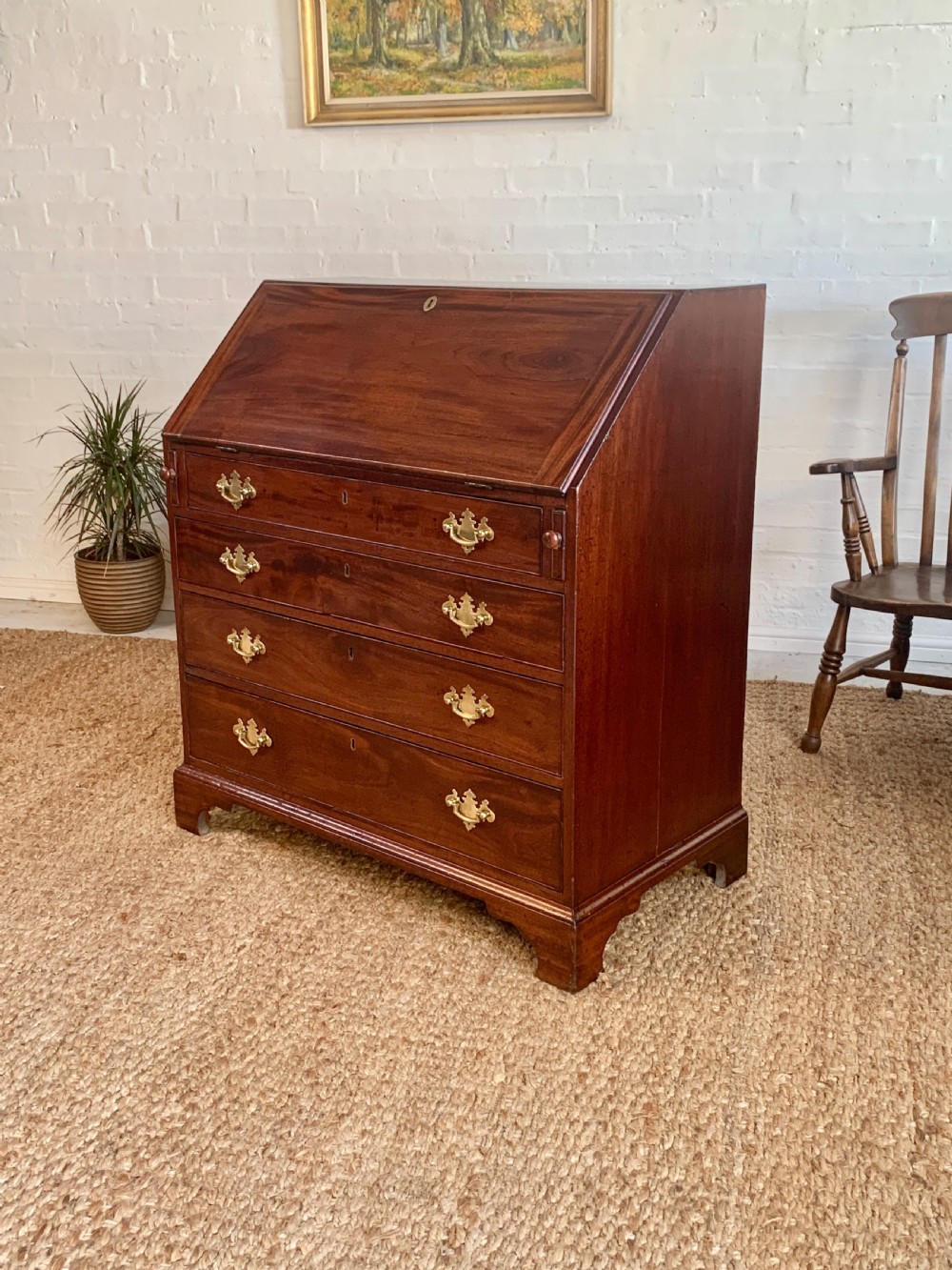 A Georgian mahogany slant-front writing bureau featuring four graduated drawers with brass batwing handles and bracket feet. View IV