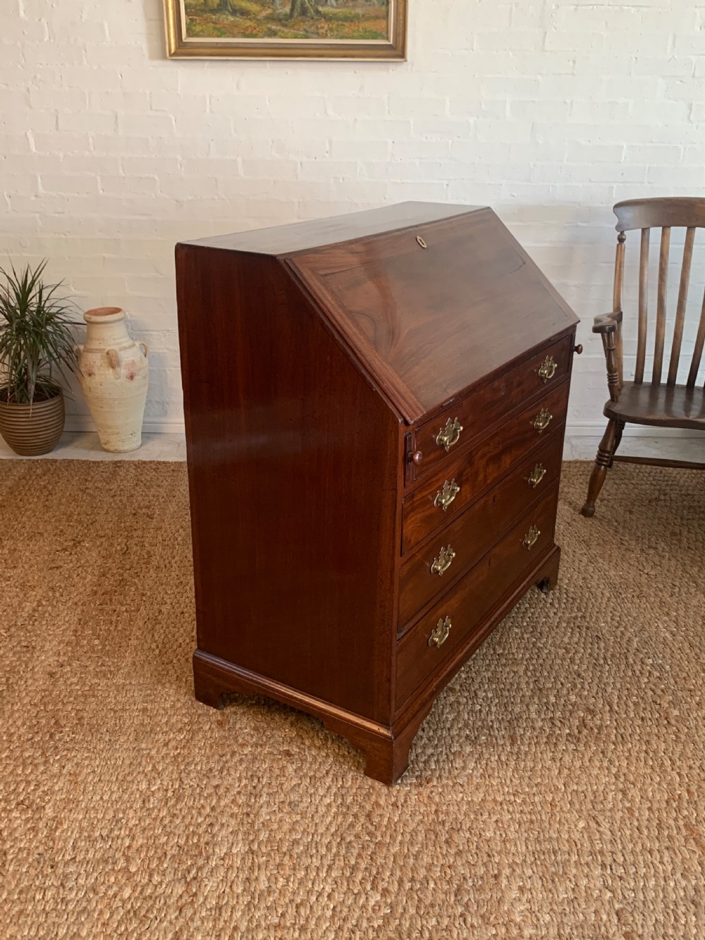 A Georgian mahogany slant-front writing bureau featuring four graduated drawers with brass batwing handles and bracket feet. View XIV