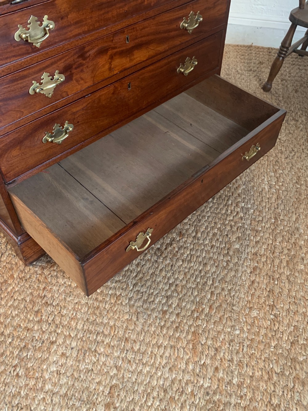 A Georgian mahogany slant-front writing bureau featuring four graduated drawers with brass batwing handles and bracket feet. View XVI