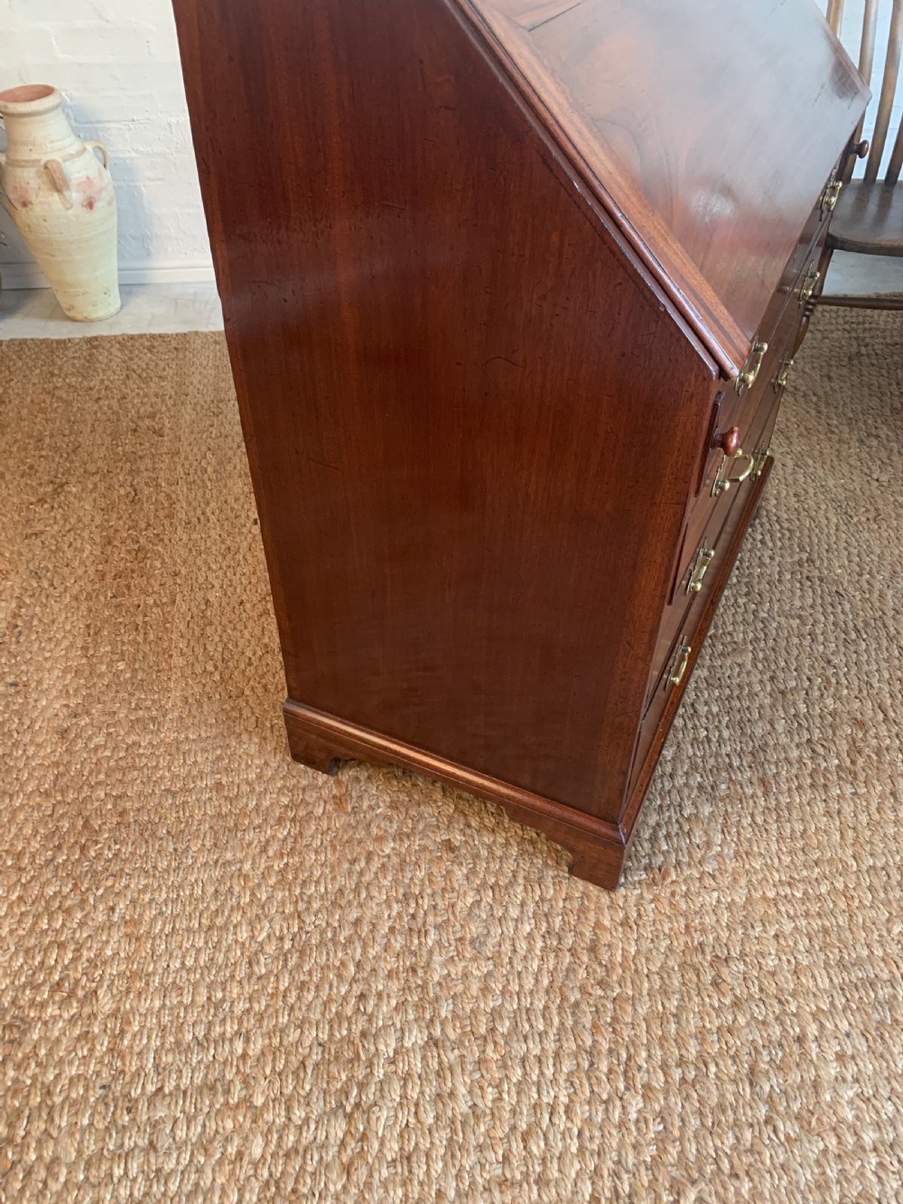 A Georgian mahogany slant-front writing bureau featuring four graduated drawers with brass batwing handles and bracket feet. View XIX