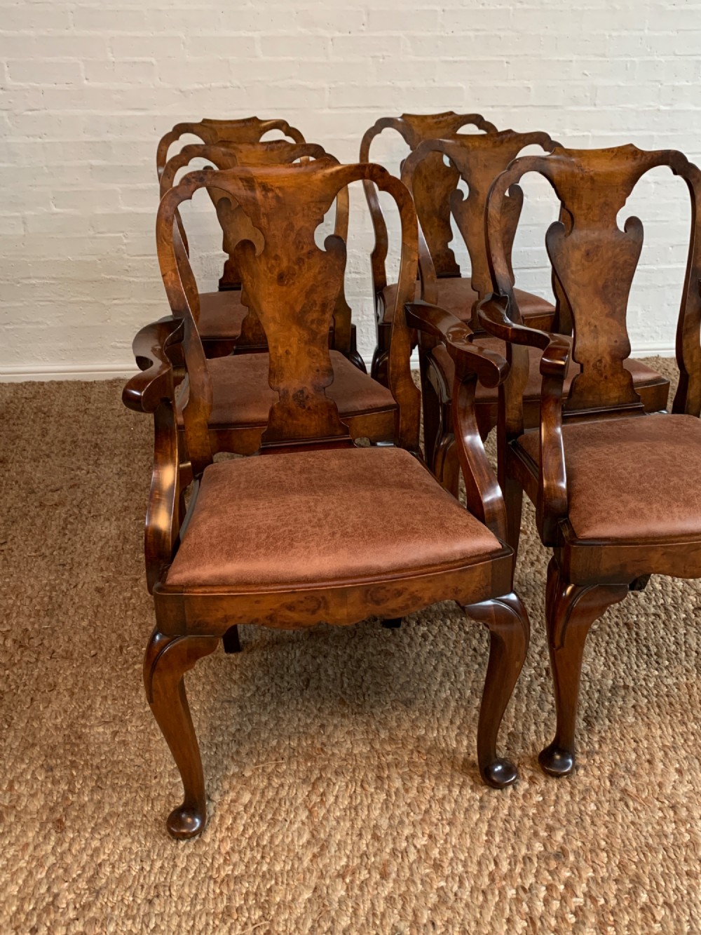 Set of six Queen Anne style burr walnut dining chairs with vasiform splat backs, padded brown fabric seats, and cabriole legs. View III