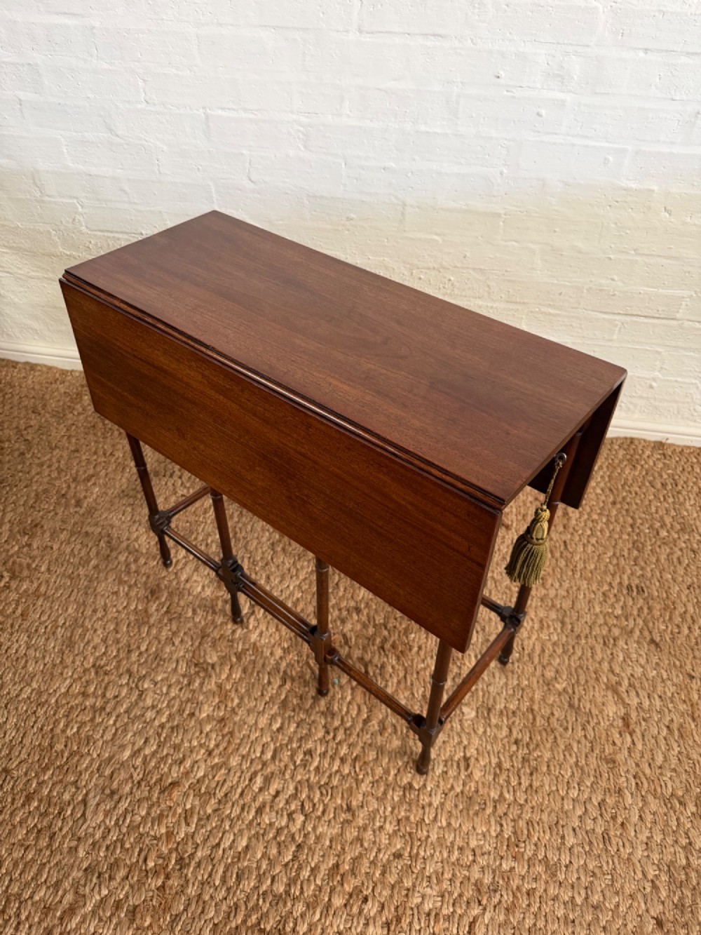 An Edwardian solid dark mahogany drop-leaf side table featuring turned faux-bamboo legs, a central drawer with a key, and a double-tier stretcher base. View II