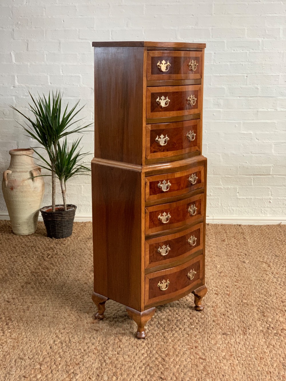 A narrow Queen Anne style walnut tallboy featuring seven drawers in a two-piece stacked design with brass handles and cabriole legs. View III