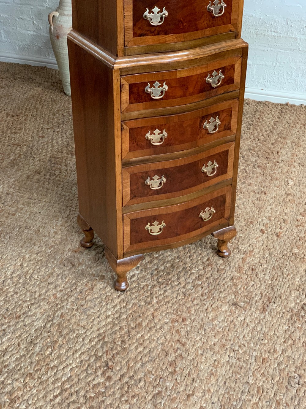 A narrow Queen Anne style walnut tallboy featuring seven drawers in a two-piece stacked design with brass handles and cabriole legs. View IV