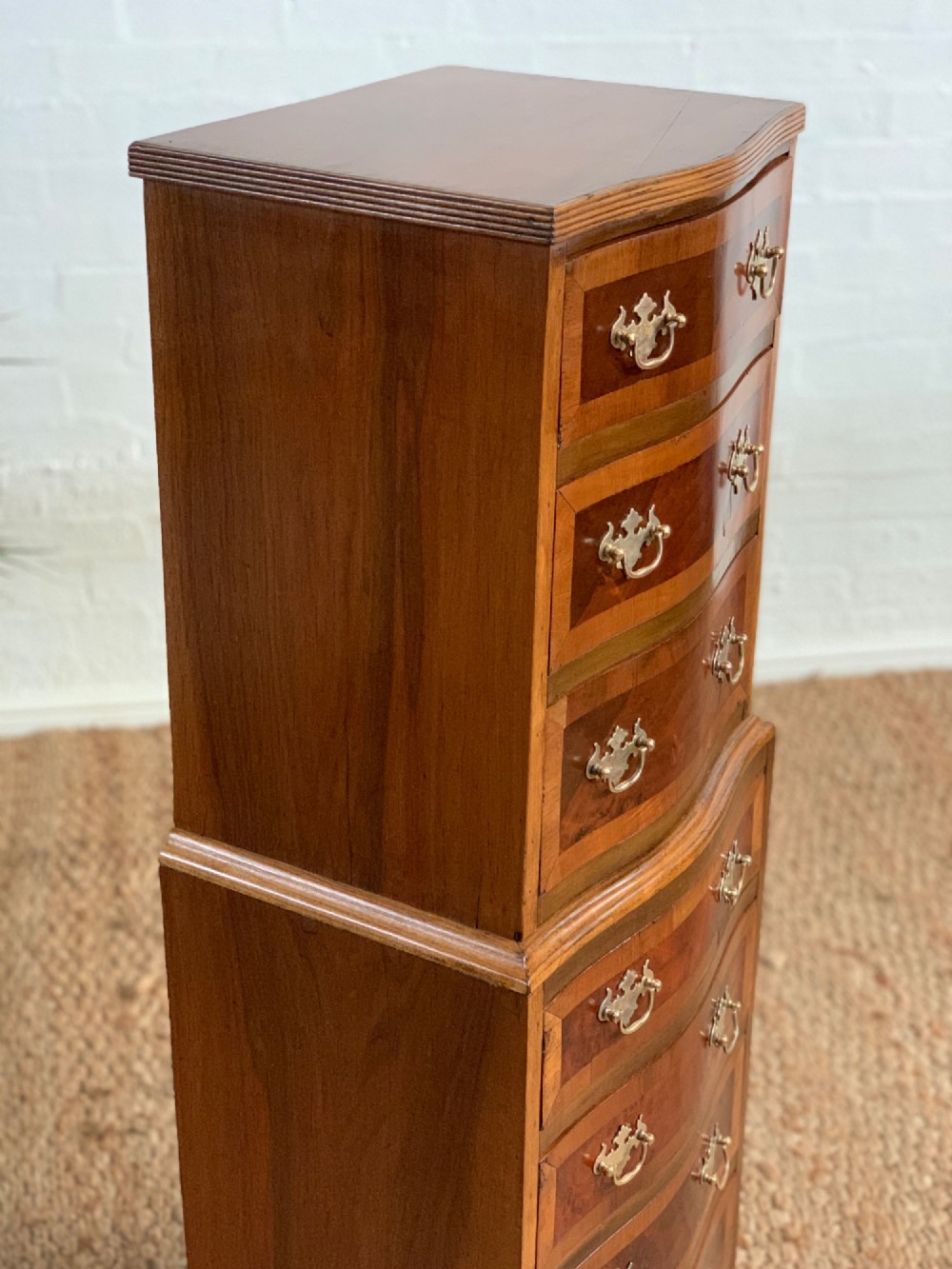 A narrow Queen Anne style walnut tallboy featuring seven drawers in a two-piece stacked design with brass handles and cabriole legs. View VI