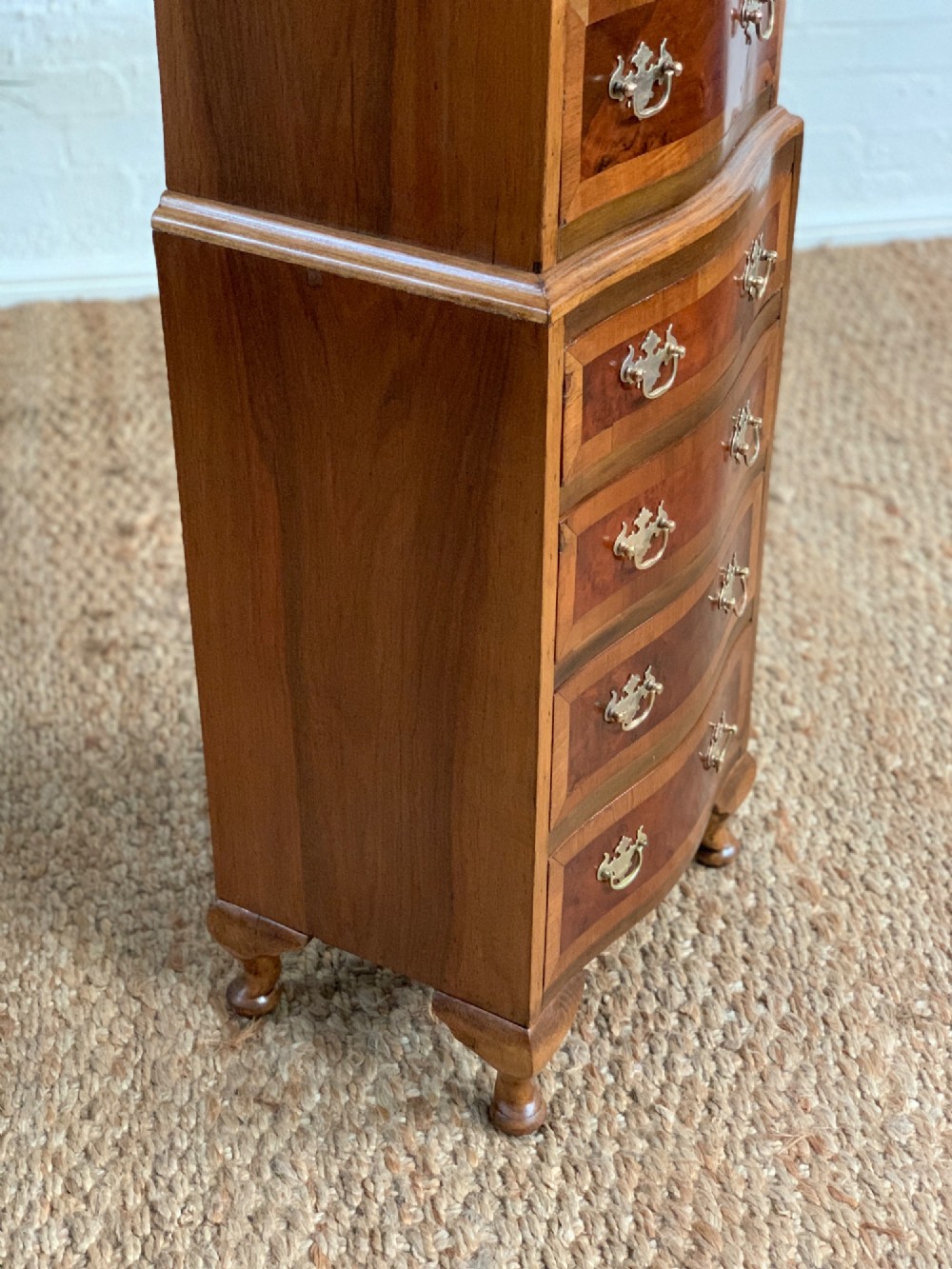 A narrow Queen Anne style walnut tallboy featuring seven drawers in a two-piece stacked design with brass handles and cabriole legs. View VII
