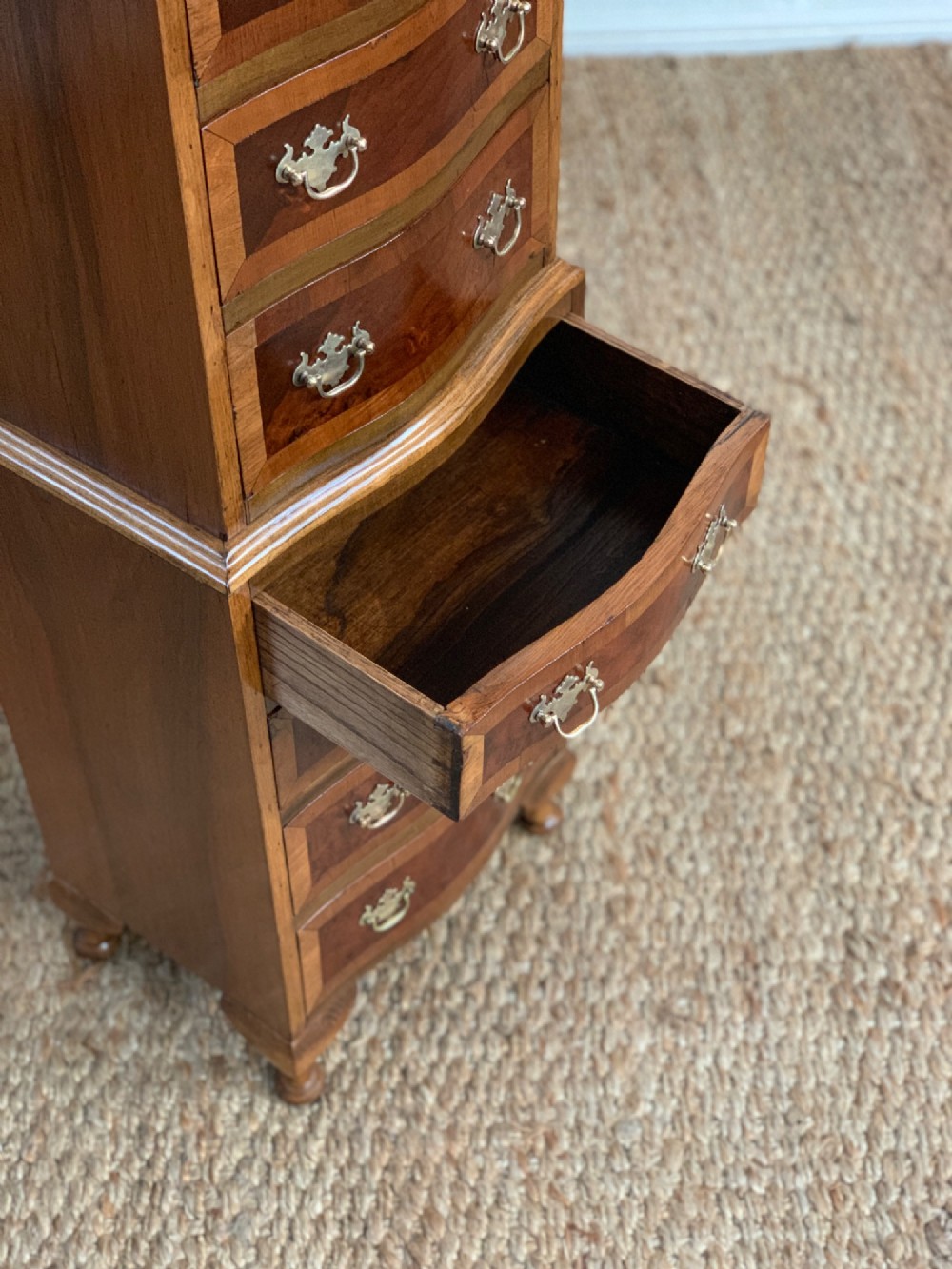 A narrow Queen Anne style walnut tallboy featuring seven drawers in a two-piece stacked design with brass handles and cabriole legs. View VIII