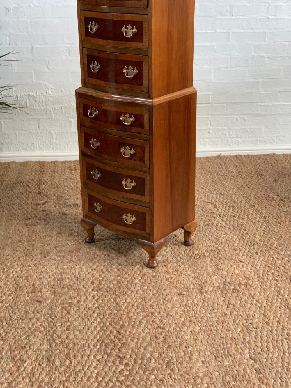 A narrow Queen Anne style walnut tallboy featuring seven drawers in a two-piece stacked design with brass handles and cabriole legs. View IX