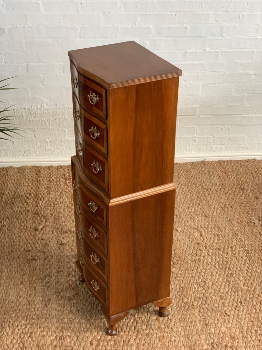 A narrow Queen Anne style walnut tallboy featuring seven drawers in a two-piece stacked design with brass handles and cabriole legs. View X