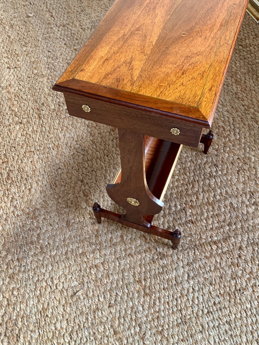 A dark mahogany Canterbury side table featuring a rectangular top, a single shallow drawer with brass knobs, and a lower V-shaped magazine trough supported on shaped uprights. View III