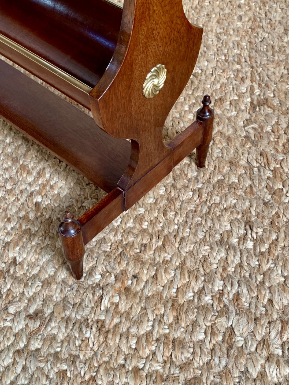 A dark mahogany Canterbury side table featuring a rectangular top, a single shallow drawer with brass knobs, and a lower V-shaped magazine trough supported on shaped uprights. View VI