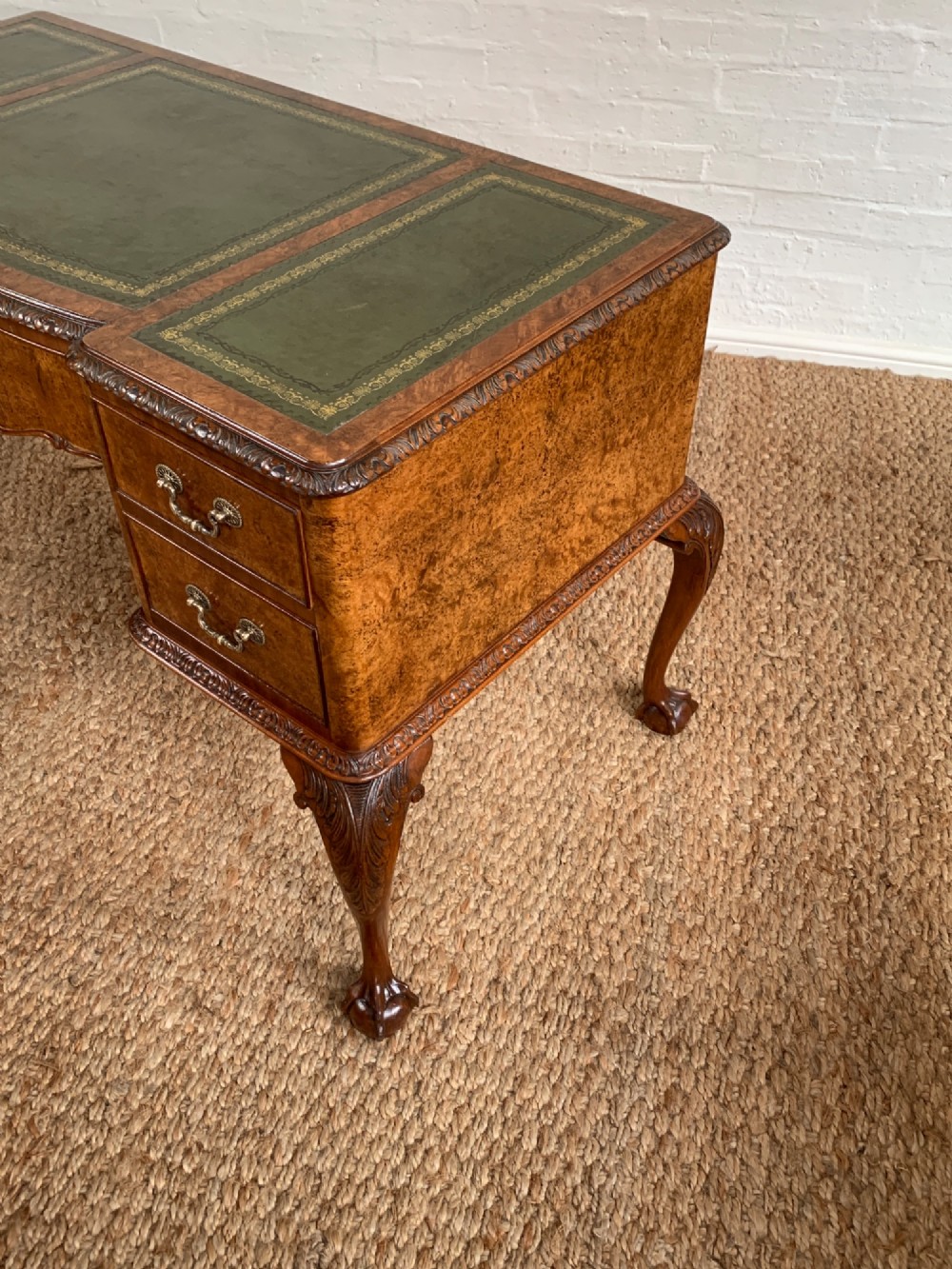 A burr walnut kneehole writing desk with four drawers, carved cabriole legs with claw and ball feet, and a green leather writing surface. View II