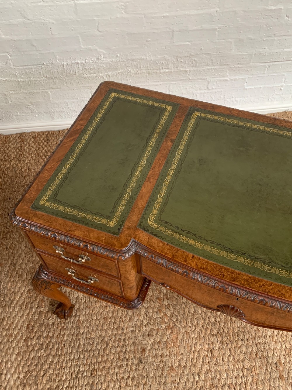A burr walnut kneehole writing desk with four drawers, carved cabriole legs with claw and ball feet, and a green leather writing surface. View III