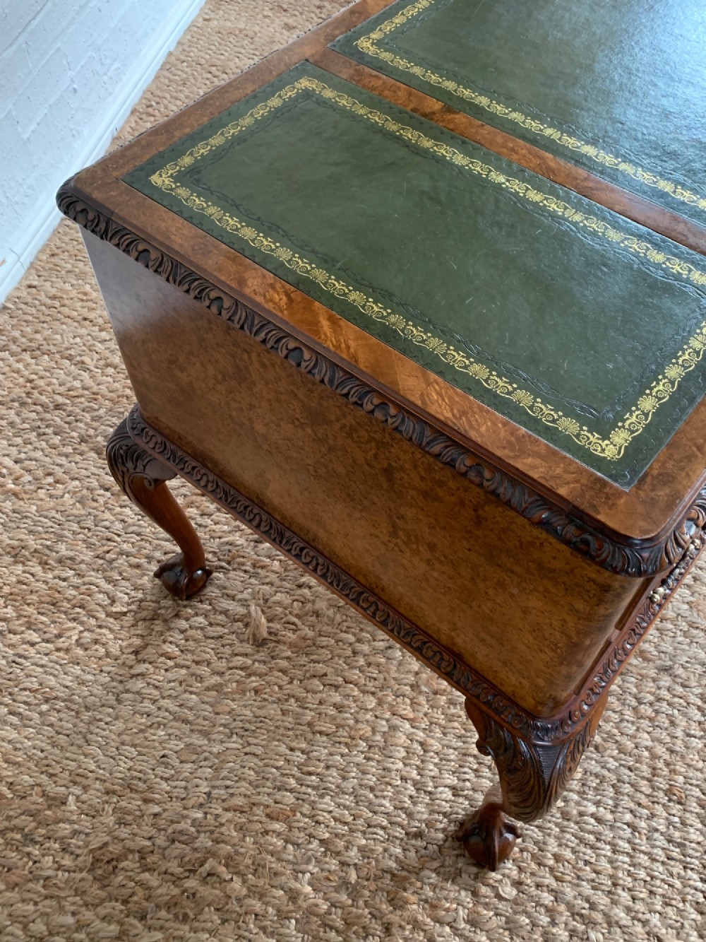 A burr walnut kneehole writing desk with four drawers, carved cabriole legs with claw and ball feet, and a green leather writing surface. View V