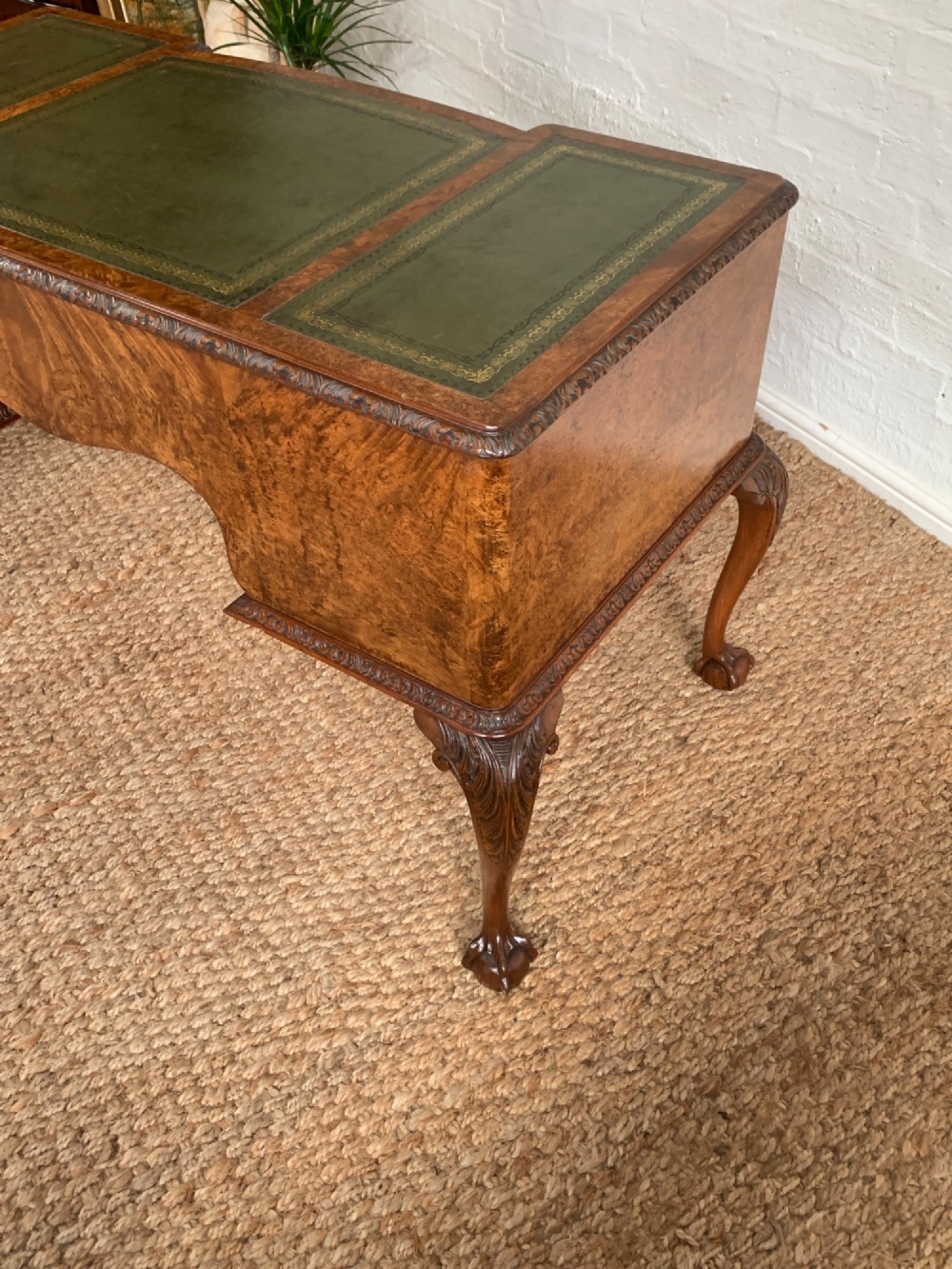 A burr walnut kneehole writing desk with four drawers, carved cabriole legs with claw and ball feet, and a green leather writing surface. View VIII