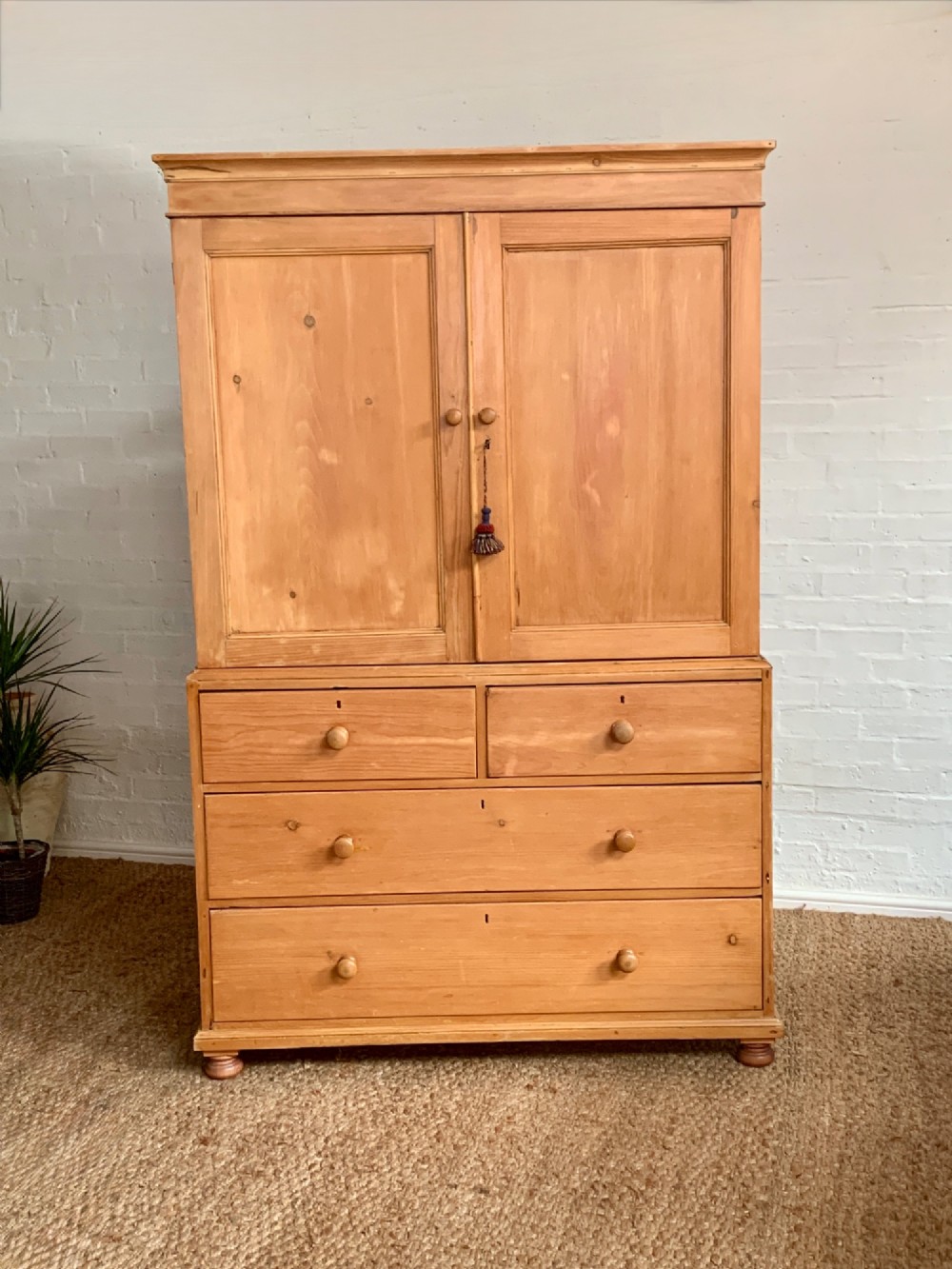 A two-piece late Victorian stripped pine dresser featuring a two-door upper cupboard and a base with two short over two long drawers with turned knobs. View II