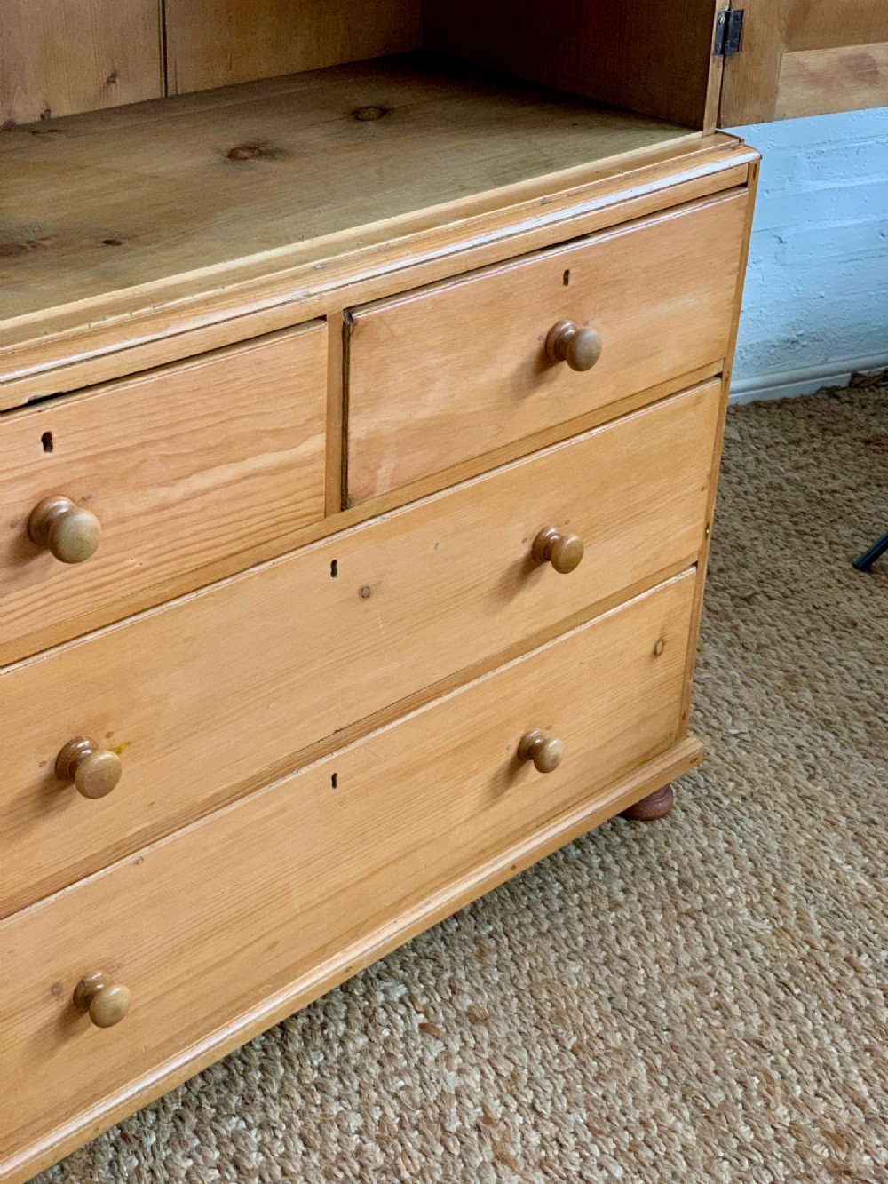 A two-piece late Victorian stripped pine dresser featuring a two-door upper cupboard and a base with two short over two long drawers with turned knobs. View VI