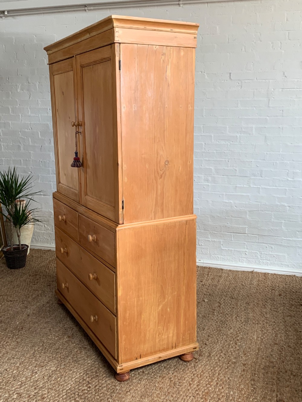 A two-piece late Victorian stripped pine dresser featuring a two-door upper cupboard and a base with two short over two long drawers with turned knobs. View X