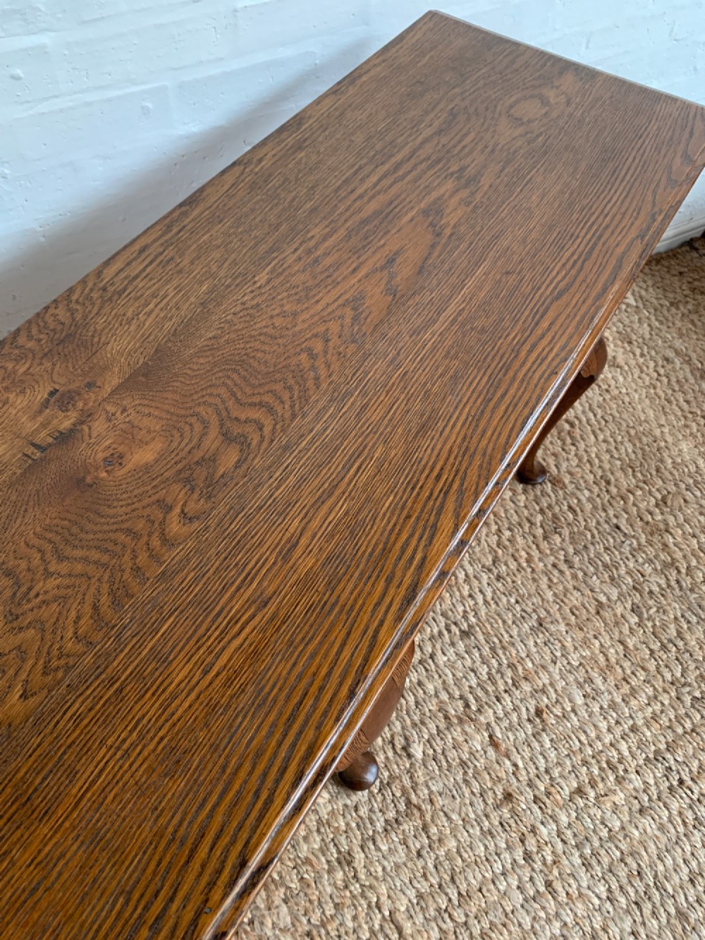 An Edwardian oak dresser base featuring three drawers with brass handles, a decorative pierced fretwork apron, and four cabriole legs terminating in pad feet. View VIII
