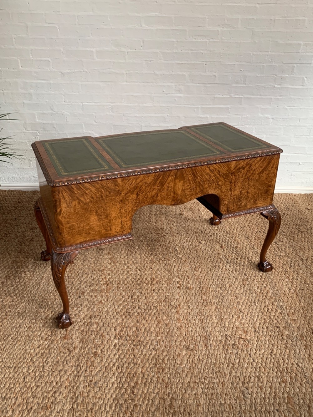 A burr walnut kneehole writing desk with four drawers, carved cabriole legs with claw and ball feet, and a green leather writing surface. View XI