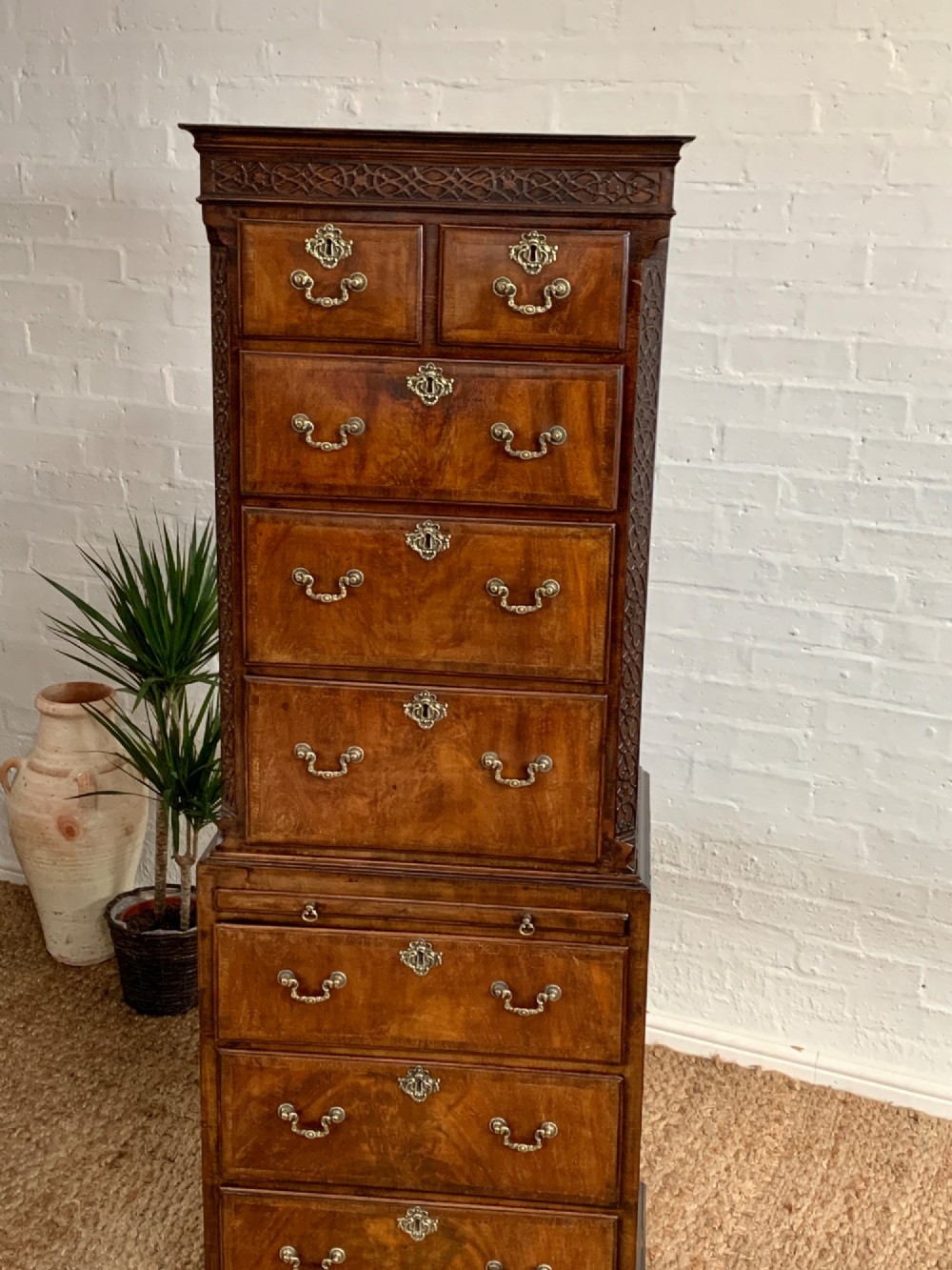 A tall 19th-century George III style burr walnut chest of drawers featuring decorative brass handles, keyhole escutcheons, carved side friezes, and bracket feet. View II