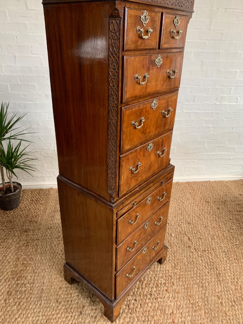 A tall 19th-century George III style burr walnut chest of drawers featuring decorative brass handles, keyhole escutcheons, carved side friezes, and bracket feet. View VII