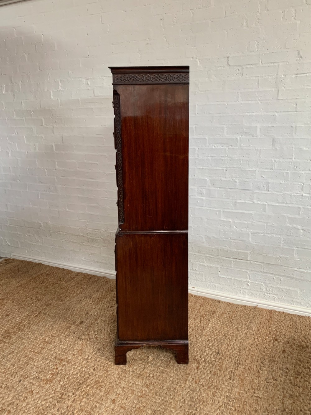A tall 19th-century George III style burr walnut chest of drawers featuring decorative brass handles, keyhole escutcheons, carved side friezes, and bracket feet. View XI