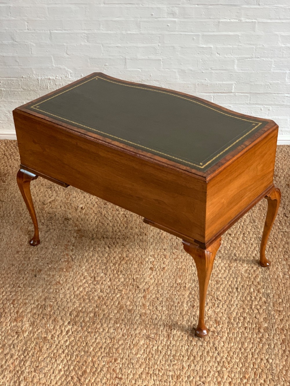 An early 20th-century burr walnut writing desk featuring an inset leather top, kneehole drawer arrangement, brass drop handles, and cabriole legs. View XIII