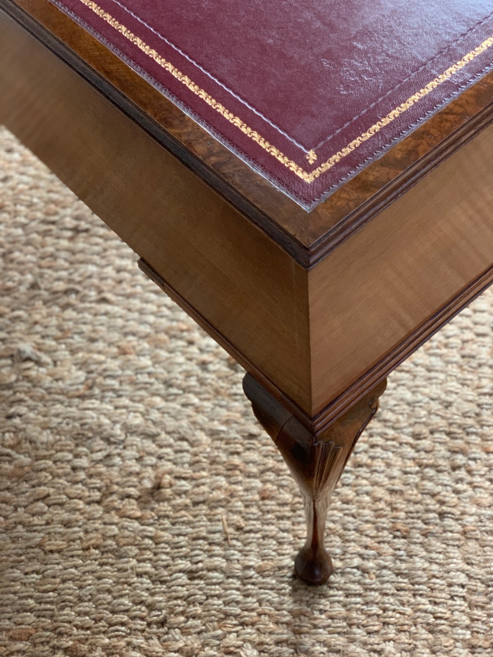 An early 20th-century burr walnut writing desk featuring five drawers with brass handles, carved cabriole legs, and a fitted kneehole. View IX