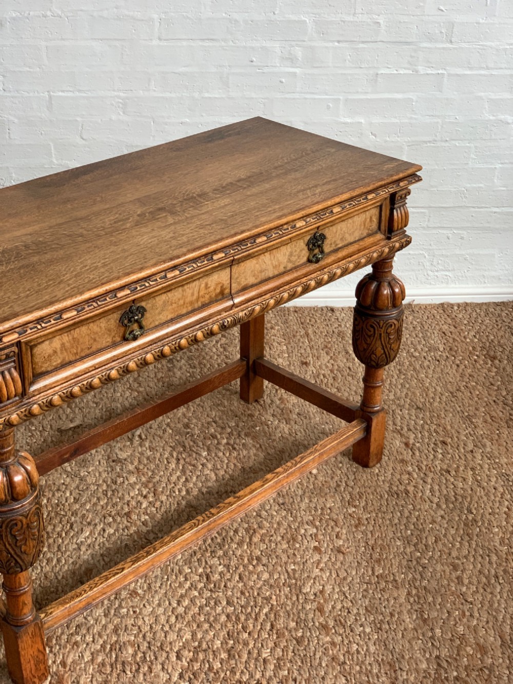 A 1920s carved oak side serving table with two drawers, brass handles, carved bulbous front legs, and a lower stretcher frame. View III