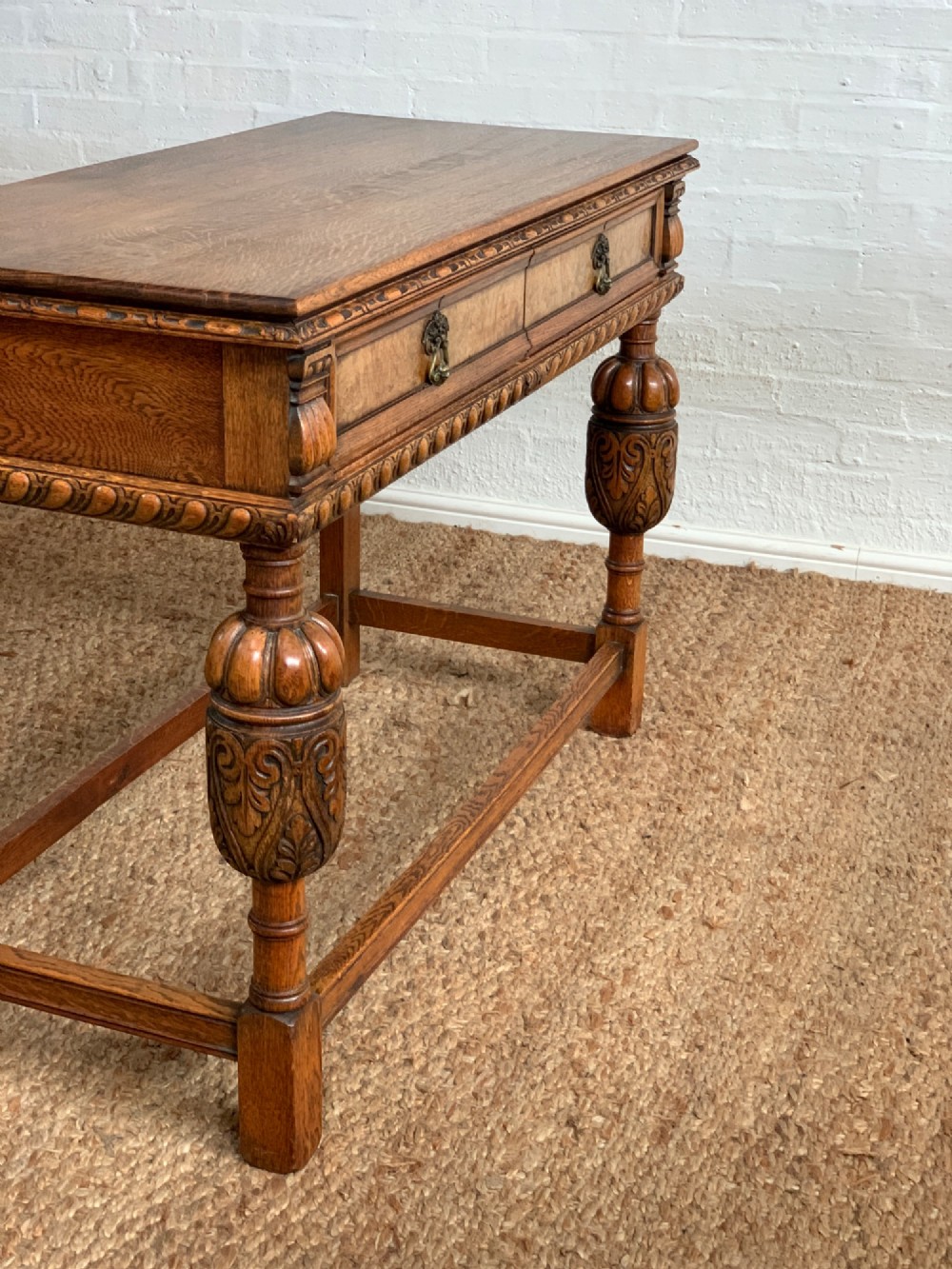A 1920s carved oak side serving table with two drawers, brass handles, carved bulbous front legs, and a lower stretcher frame. View IX