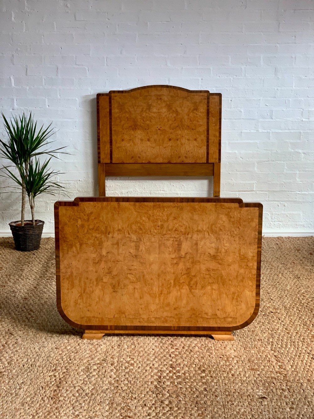 An Art Deco single bed frame crafted from figured burr walnut veneer with crossbanded borders, featuring a gently arched headboard and rounded footboard. View II