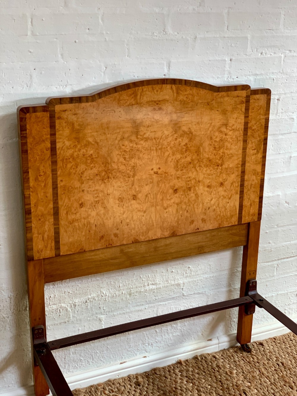 An Art Deco single bed frame crafted from figured burr walnut veneer with crossbanded borders, featuring a gently arched headboard and rounded footboard. View III