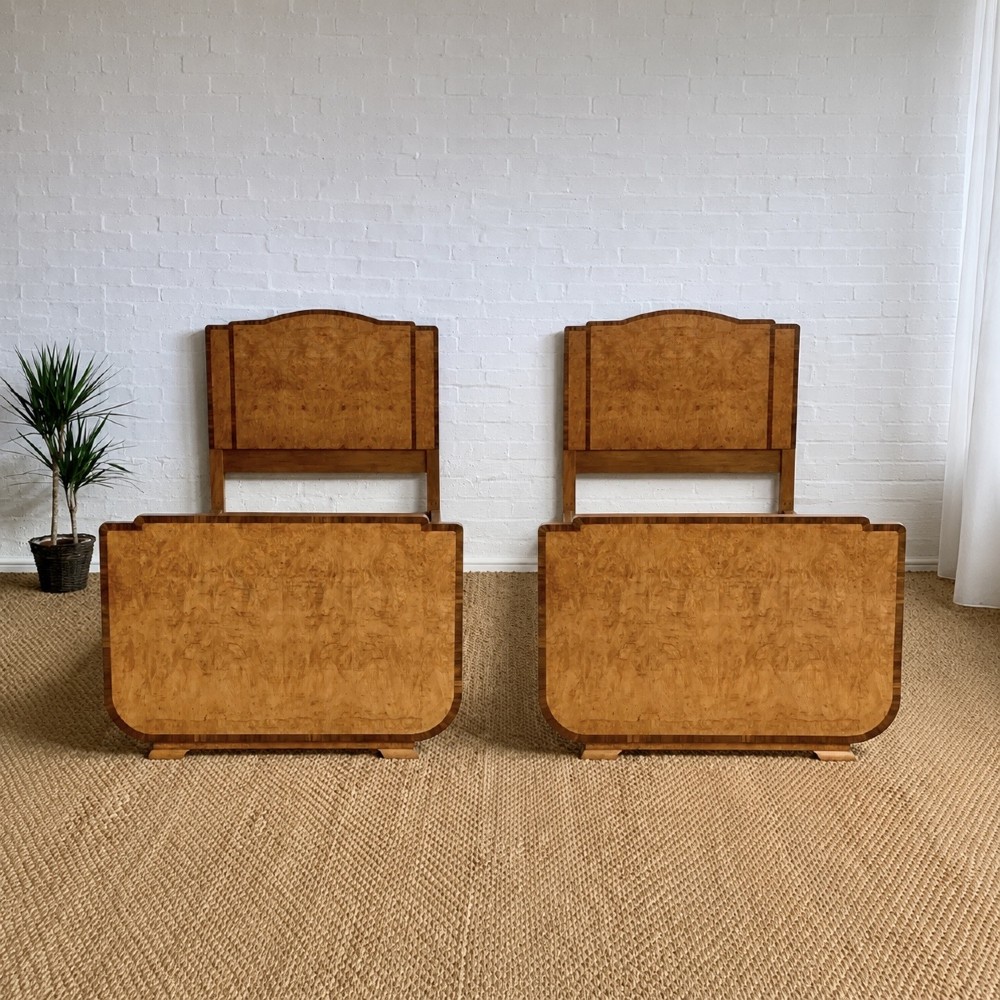 An Art Deco single bed frame crafted from figured burr walnut veneer with crossbanded borders, featuring a gently arched headboard and rounded footboard. View VI