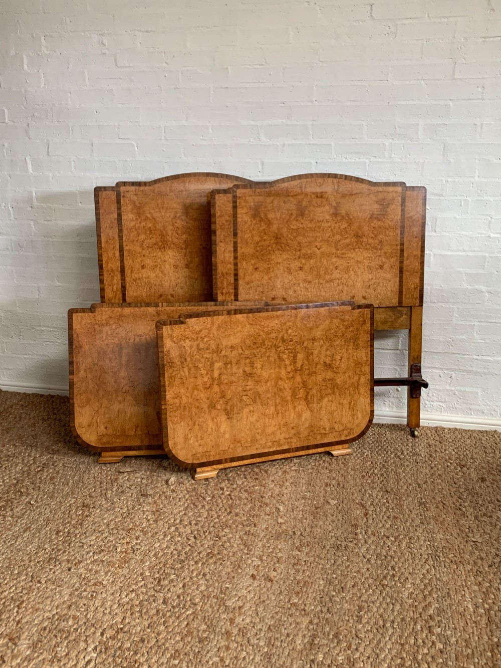 An Art Deco single bed frame crafted from figured burr walnut veneer with crossbanded borders, featuring a gently arched headboard and rounded footboard. View VII