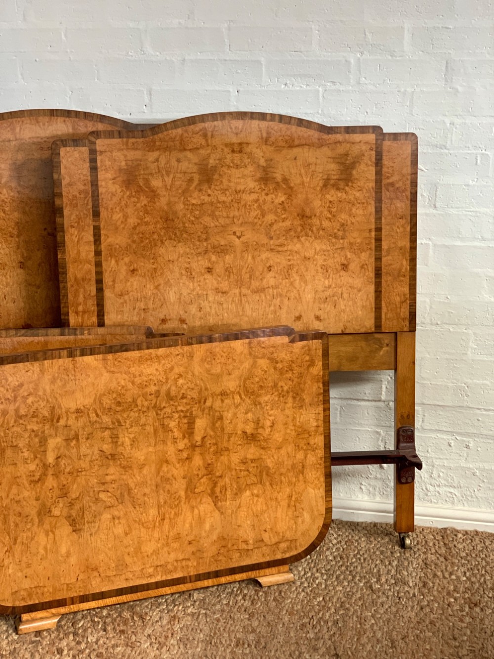 An Art Deco single bed frame crafted from figured burr walnut veneer with crossbanded borders, featuring a gently arched headboard and rounded footboard. View VIII