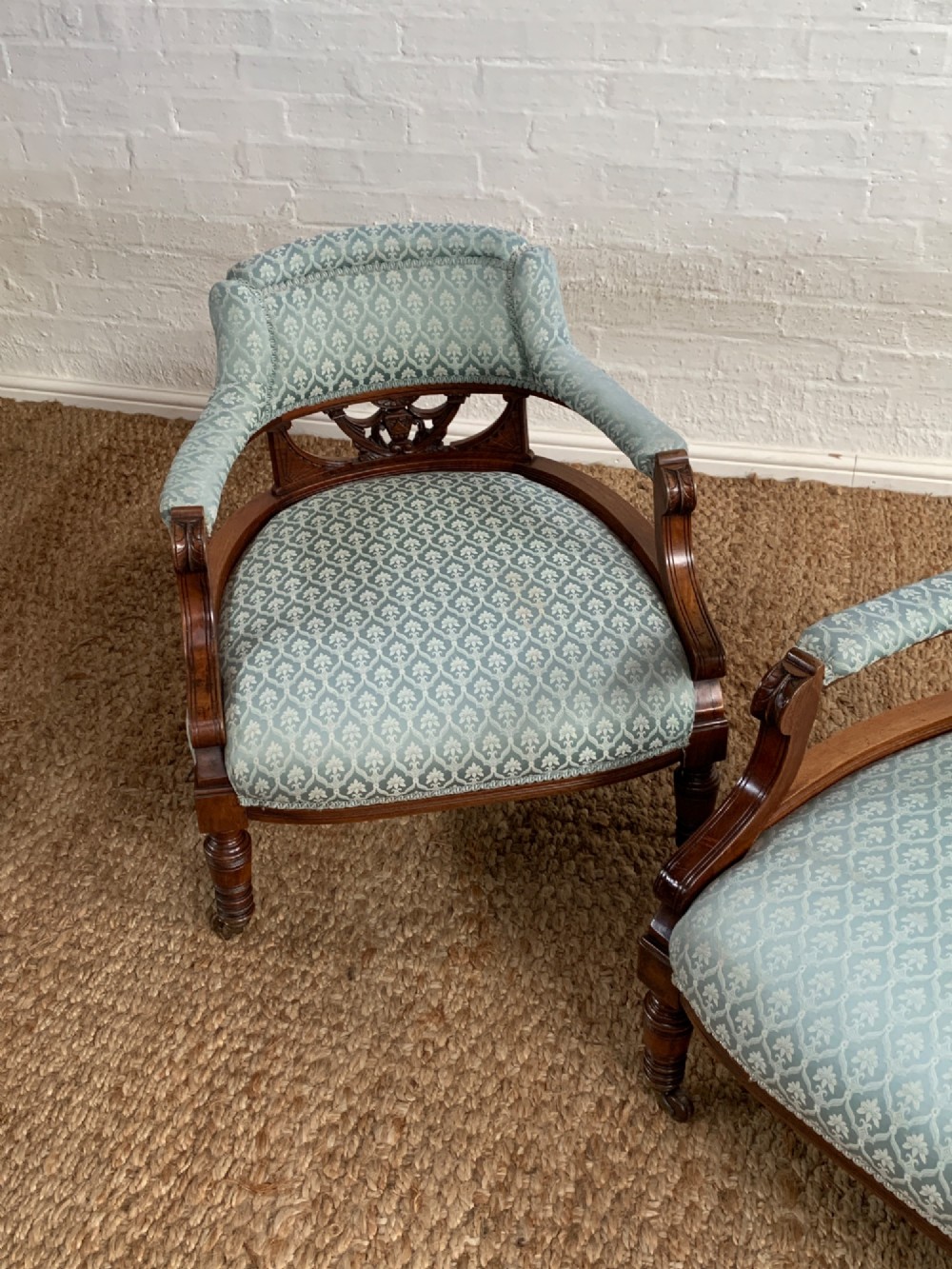 A pair of Edwardian walnut tub armchairs with pale blue patterned upholstery, turned front legs, and castors. View III